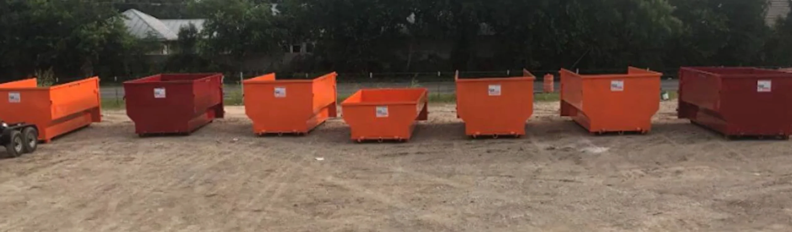 Multiple orange roll-off dumpster containers New Braunfels TX construction job site Veramendi Mayfair I-35 Comal County